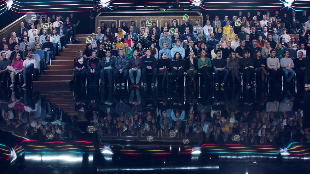 TV studio audience with AR 'Whats-app'-Logos over their heads and reflections on the floor